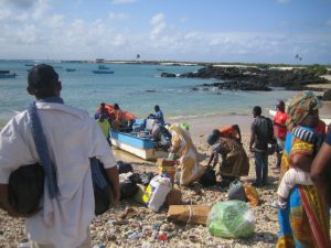 Komoren - Das Land: Boot nach Mohéli mit Menschen am Strand